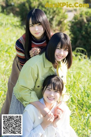 A group of young women standing next to each other in a field.