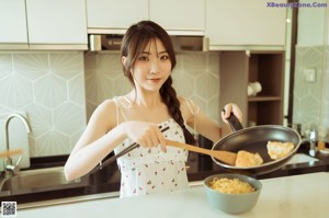 A woman sitting on the floor in front of an open refrigerator.