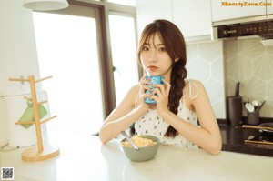 A woman sitting on the floor eating a piece of food.