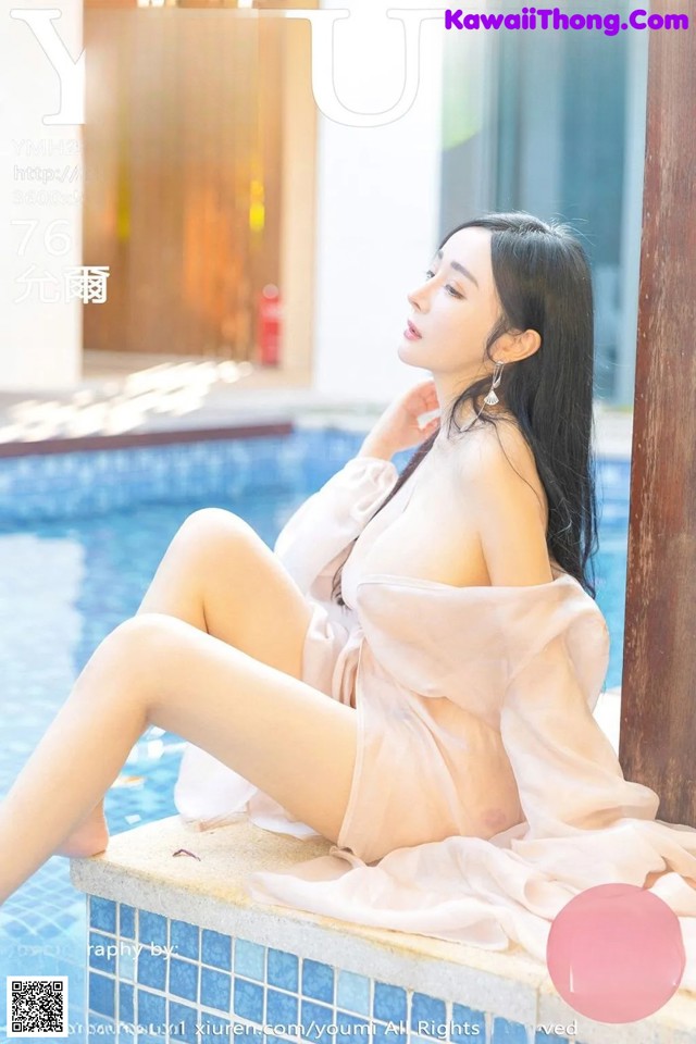 a woman sitting on the edge of a swimming pool
