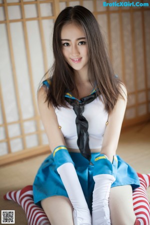 A woman in a blue dress posing for the camera.