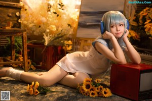 A woman with long blue hair holding a bunch of flowers.