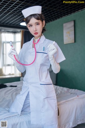 A woman in a white nurse outfit posing for a picture.
