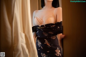 A woman in lingerie sitting on a bed in a room.