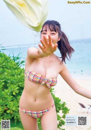A young woman is holding a hose and smiling.