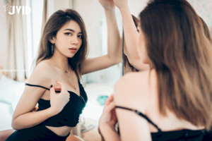 A woman in a white lingerie is taking a shower.