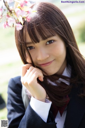 A woman in a school uniform sitting on some steps.