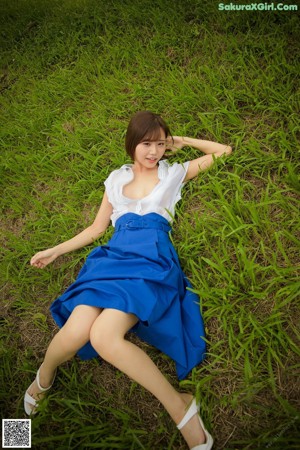 A woman laying on the ground in a field of flowers.