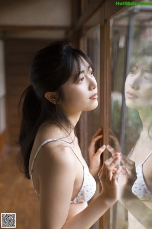 A woman sitting on the floor in front of a window.