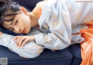 A woman sitting on a bed holding a blanket.