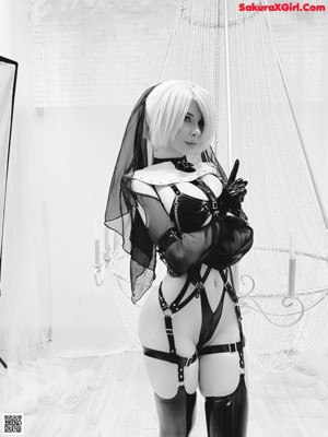 A woman in a black lingerie and thigh high boots posing for a picture.