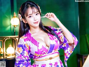 A woman in a pink kimono posing for the camera.