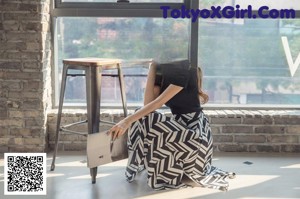 a woman standing in front of a window talking on a cell phone