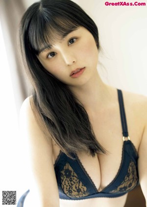 A woman in a blue lingerie leaning against a wall.