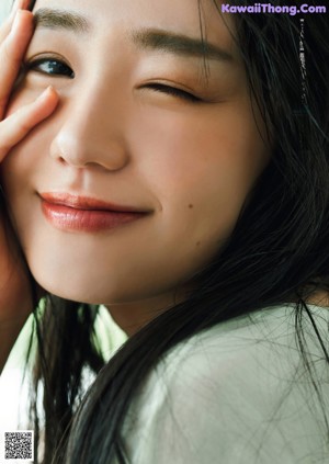 A woman laying in bed with her eyes closed and smiling.