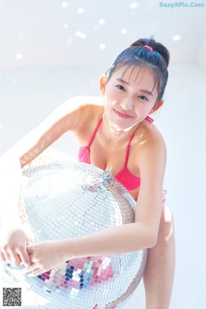 A woman in a pink bikini posing for a picture.
