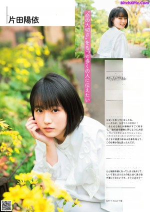 A woman in a white sweater holding a leaf in her hand.