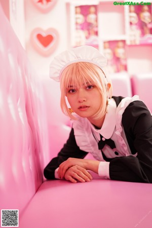 A woman in a maid outfit holding a drink.