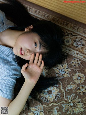 A woman with long black hair wearing a black bra.