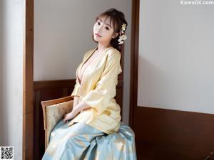 A woman sitting on top of a white bed.
