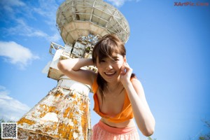 A woman in a yellow bikini is posing for the camera.