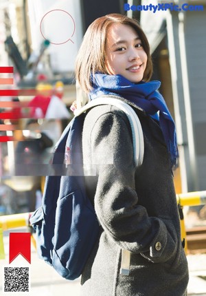 A woman wrapped up in a blanket sitting on a bench.
