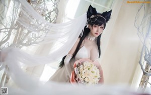 A woman in a white dress with a cat ears headband.