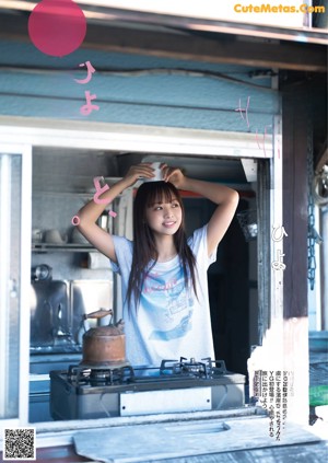 A woman standing in the doorway of a blue house.