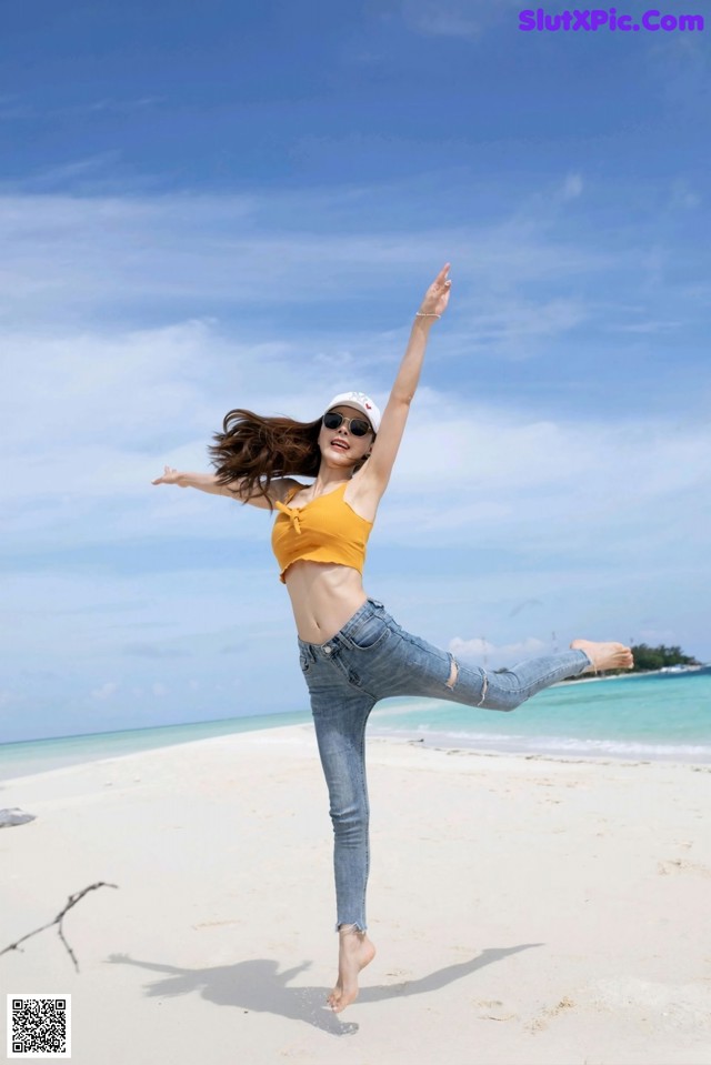 A woman jumping in the air on a beach.