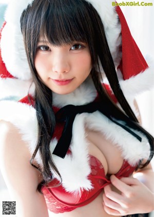 A woman in a santa claus outfit looking out of a window.